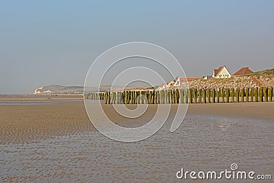 Rows of wooden poles for the cultivation of bouchot mussels and village of Wissant behind Stock Photo