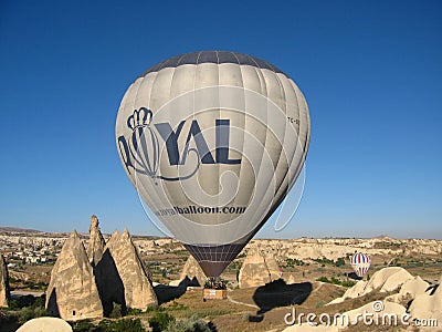 Royal ballons flying in the sunrise light in Cappadocia, Turkey above the Fairy ChimneysÂ rock formationÂ nearby Goreme Editorial Stock Photo
