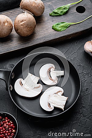 Royal champignons Parisian champignons in cast iron frying pan on black background Stock Photo