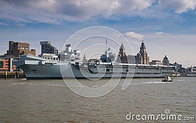 The Royal Navy`s Prince of Wales aircraft carrier, moored at the historic, UNESCO listed Liverpool waterfront on the River Mersey Editorial Stock Photo