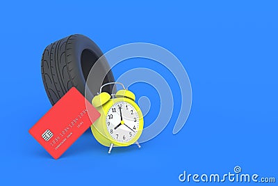 Rubber tyre near credit card and alarm clock. The cost of replacing car wheels Stock Photo