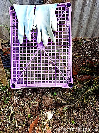 rubber working gloves on a plastic fruit crate Stock Photo