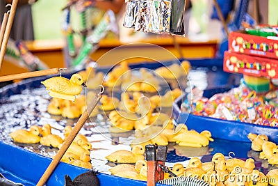 Rubber yellow ducks with hooks in their heads. Fairground hook a rubber duck chance game Stock Photo