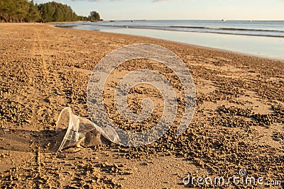 Rubbish or garbage used plastic glass left on beach. Stock Photo