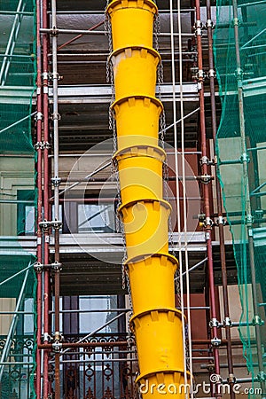 Rubble drain pipes on the external faÃ§ade of a building under construction or renovation Stock Photo