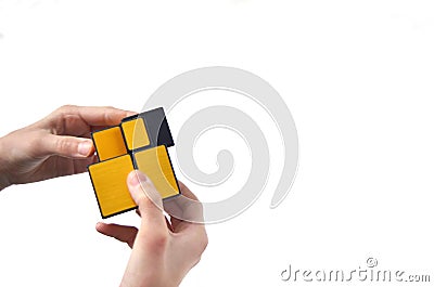 Rubik`s cube in the hands of a child, close-up, top view, white wooden background. A girl holds a Rubik`s cube and plays with it. Editorial Stock Photo