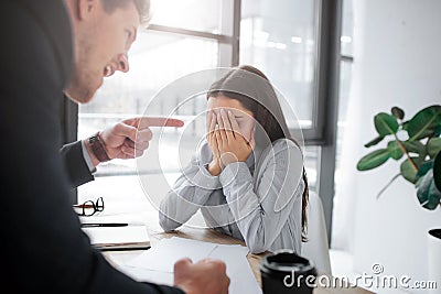 Rude young man point on brunette. She covers face with hands. Model afraid. Guy mad at her. He scream. she cry. Stock Photo