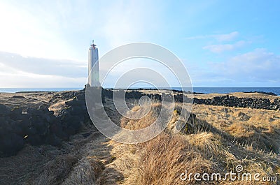 Rugged Rocks and Tall Grass Fields Surrounding Malarrif Lighthouse Stock Photo