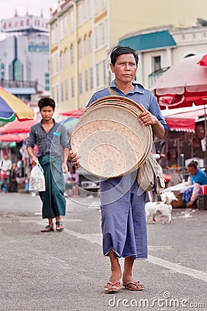 Traditional dressed manwalks on a market place in Ruili, Yunnan Province, China Editorial Stock Photo