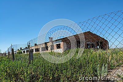 Ruined abandoned old cattle farm building during summer in the lost forgotten village Stock Photo