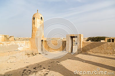 Minaret in ruined ancient old Arab pearling and fishing town Al Jumail, Qatar. The desert, coast of Persian Gulf. Pile of stones. Stock Photo