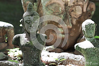 Ruined ancient stone buddha statue in front of huge buddha head statue wallpaper, broken body art crafting souvenir sculpture, sit Stock Photo