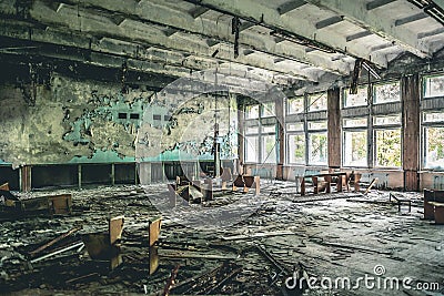 Ruined assembly hall with debris in abandoned Pripyat school Stock Photo