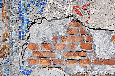 Ruined brick wall made of small mosaics. Finishing the surface of the building with pieces of stone. Intarsia. Stock Photo