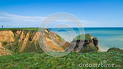 Ruined clay slope by the sea. Cracked clay cliff on the coast. Stock Photo