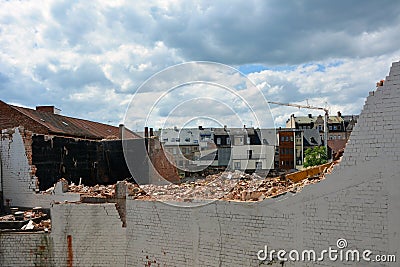 A ruined old building in the form of a pile of bricks and a half-destroyed wall Stock Photo