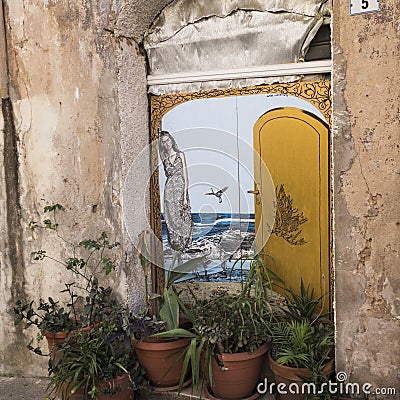 Ruined wall with an optical painting of a woman at the door Editorial Stock Photo