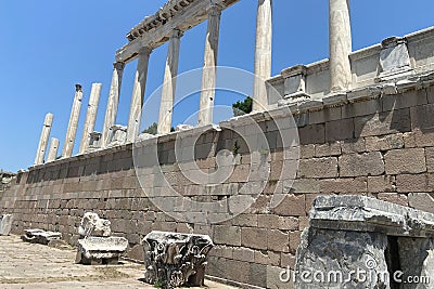 Ruins ancient city stone temple in izmir, top arches, keystones, columns, torso statue, high stone wall Stock Photo