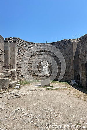 Ruins ancient city stone temple in izmir, top arches, keystones, columns, torso statue, high stone wall Stock Photo