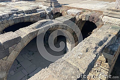 Ruins ancient city stone temple in ?zmir, top arches, keystones, columns, torso statue, high stone wall Stock Photo