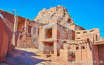 The ruins of ancient fort behind the medieval adobe houses in hilly street of Abyaneh village Stock Photo