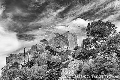 The ruins of the ancient medieval castle Monolithos against a dramatic sky, Rhodes island, Greece Stock Photo