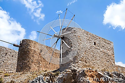 Ruins of ancient windmills on rocky mountains with blue cloudy sky Stock Photo