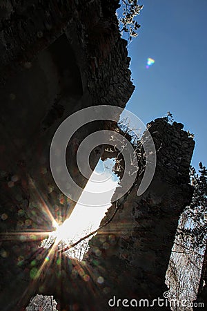 Ruins of a castle in the middle of a snowy forest at sunse Stock Photo