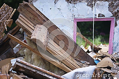 Ruins of a destroyed wooden house. Fragments of walls, boards, interior details. Summer sunny day. Stock Photo