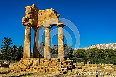 Ruins of Greek Temple of Castor and Pollux with Agrigento in the Background Stock Photo