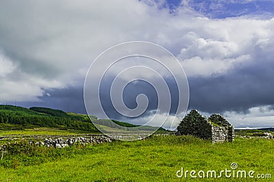 Ruins of old Irish cottage with stone walls surrounded by the countryside Stock Photo