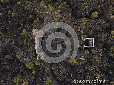 Ruins at Paricutin Volcano situated on a rocky landscape surrounded by lush greenery Stock Photo