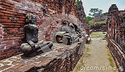 Ruins of stupa and statue of Buddha in Wat Mahathat, the ancient Thai temple in Ayutthaya Historical Park. Stock Photo