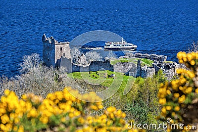 Ruins of Urquhart Castle against boat on Loch Ness in Scotland Stock Photo