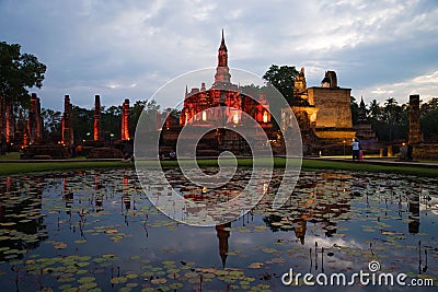 The ruins of Wat Mahathat in the festive lighting. Twilight in the historical Park of Sukhothai. Thailand Editorial Stock Photo