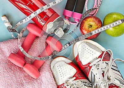 ruits, dumbbells, water bottle, rope, sneakers and meter on a blue background Stock Photo