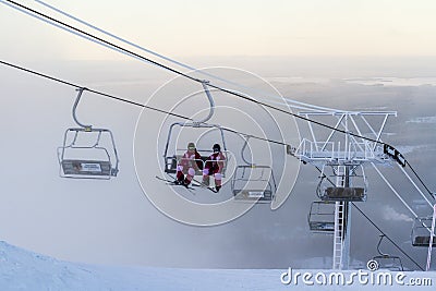 Ruka, Finland - November 27, 2012: Skiers are sitting on the chair ski lift at Ruka ski resort in freezing day Editorial Stock Photo