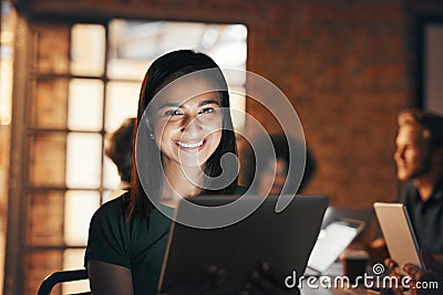 Rule number 1 Always beat and defeat the deadline. Portrait of a designer using her tablet with her colleagues in the Stock Photo