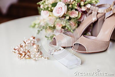 A rundown plan cropped frame, bride perfume, jewelry for the wedding hairstyle, earrings and barefoot on a light Stock Photo