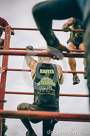 Runner climbing structure in a test of extreme obstacle race Editorial Stock Photo