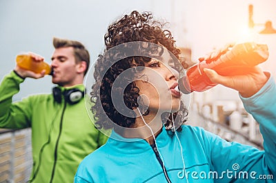 Man and woman drinking energy drink from bottle after fitness sport exercise Stock Photo