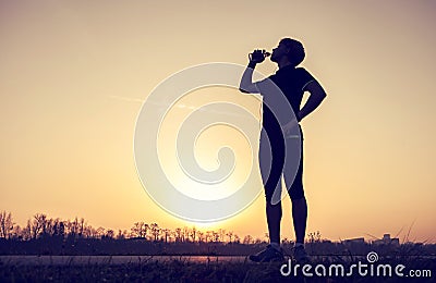Runner drinks water after training Stock Photo