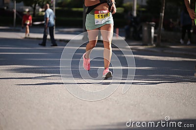 runner feet on the asphalt in a city race shoes mussles legs soprts Editorial Stock Photo