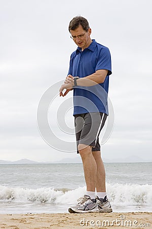 Runner looking at stop watch Stock Photo