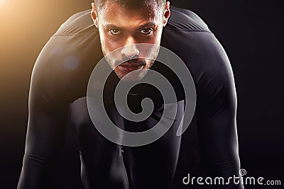 Runner man, start and isolated portrait or run, race and intense focus in dark studio background. Serious, athlete and Stock Photo