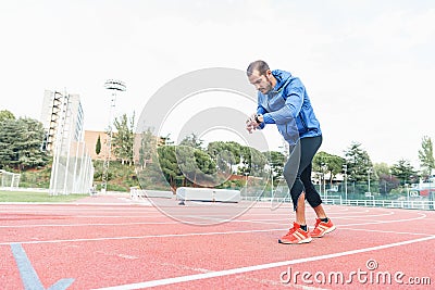 Runner ready to run is looking at his watch. Stock Photo