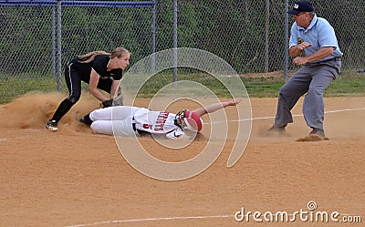 Runner slides into a base in a softball game Editorial Stock Photo