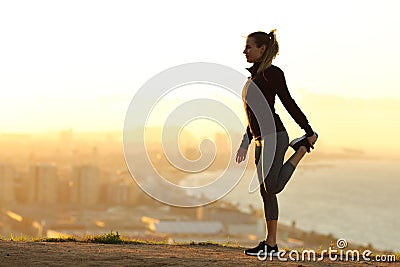 Runner stretching leg in city outskirts Stock Photo