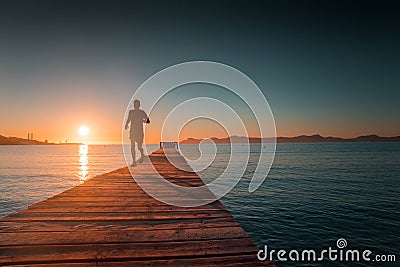 Runner train in the morning. Pier, sea, sunrise in background Stock Photo