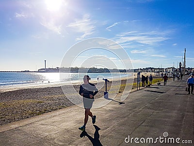 Runner on Weymouth beach Editorial Stock Photo